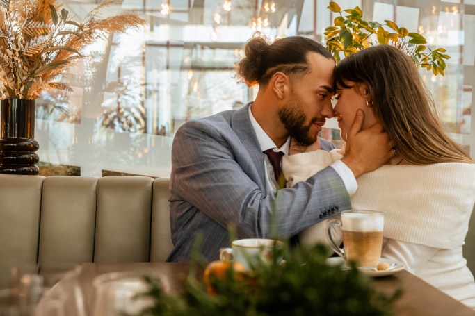 Intimates Couple Shooting Café Köln – Stirnkuss und Umarmung am Tisch © Chirlyart