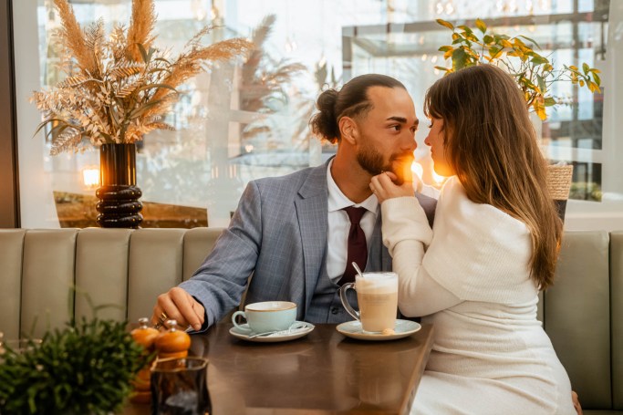 Café Couple Shooting Köln – Paar küsst sich zart bei Kaffee im Restaurant © Chirlyart