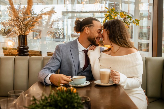 Paarfotografie Café Köln – Paar lacht und küsst sich, spontaner Moment © Chirlyart