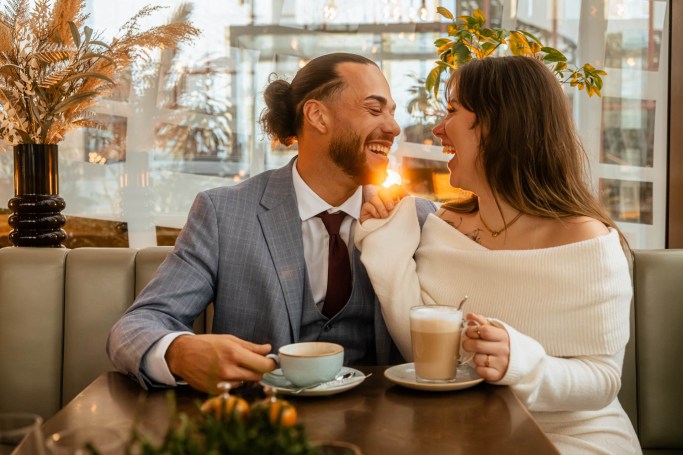 Couple Reportage Köln – Paar lacht ausgelassen im Café, spontaner Moment © Chirlyart