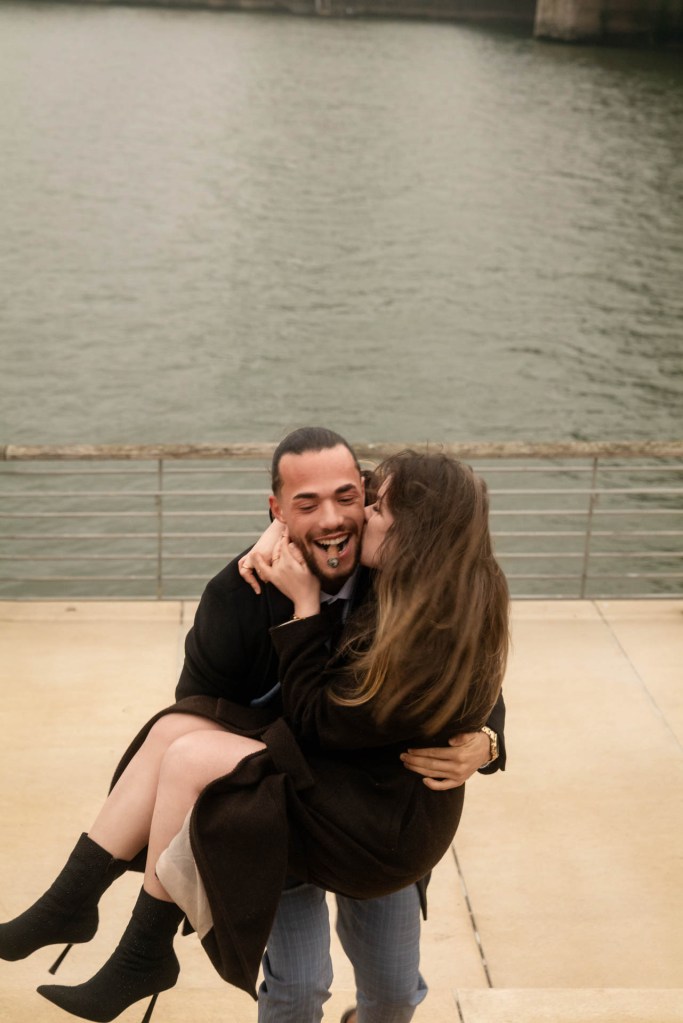 Paarfotografie Rhein Köln – Paar umarmt sich lachend am Wasser, Herbst 2025 © Chirlyart