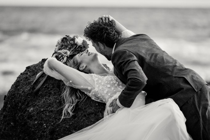 Elopement Teneriffa – Brautpaar küsst sich am Strand, Atlantik Hintergrund © Chirlyart