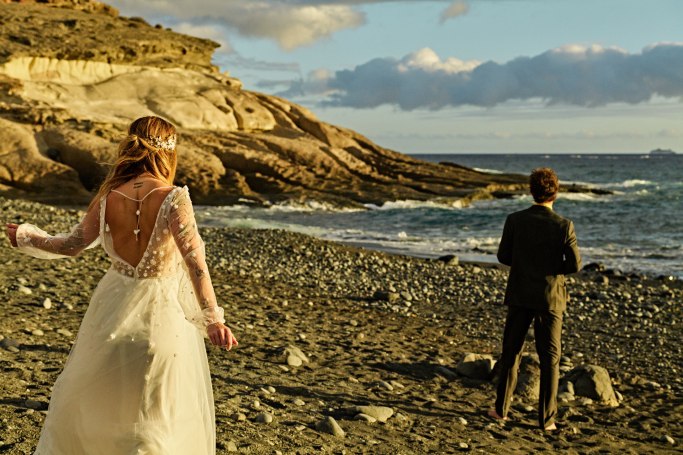 Hochzeit Kanaren Teneriffa – Brautpaar küsst sich am Strand, warmes Sonnenlicht © Chirlyart
