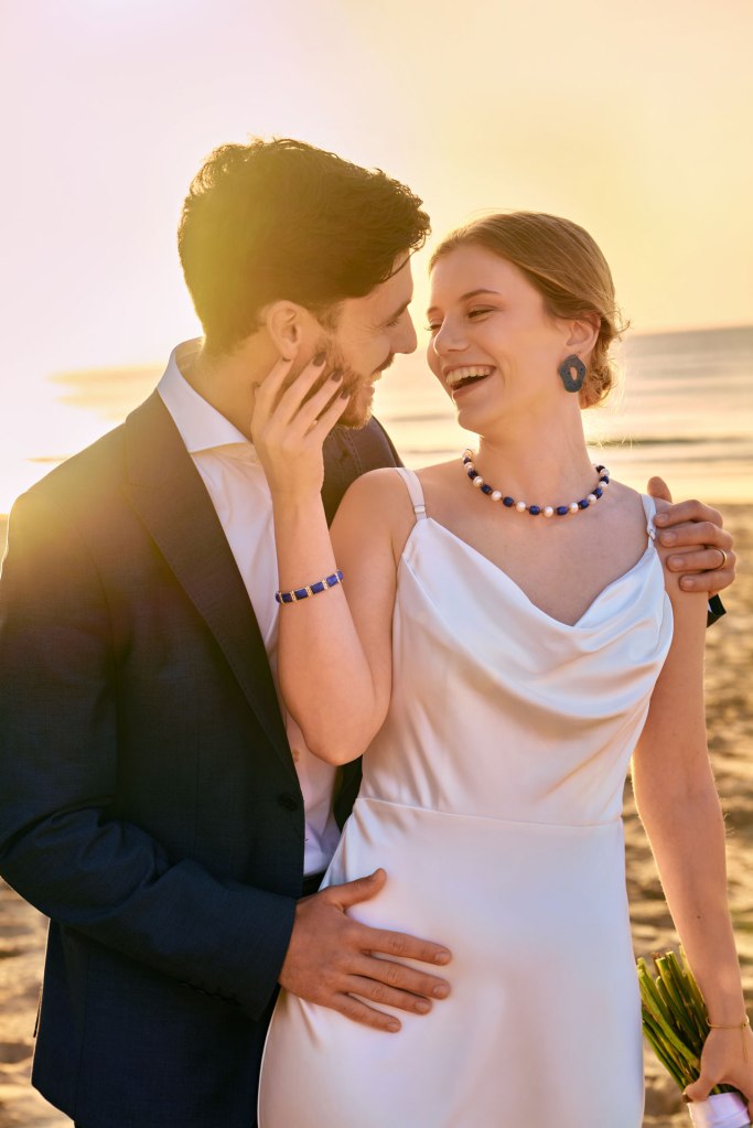 Elopement Algarve – Brautpaar steht am Strand, atemberaubendes goldenes Abendlicht Portugal © Chirlyart
