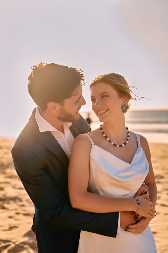 Strandhochzeit Algarve – Paar umarmt sich, warmes goldenes Licht Portugal © Chirlyart