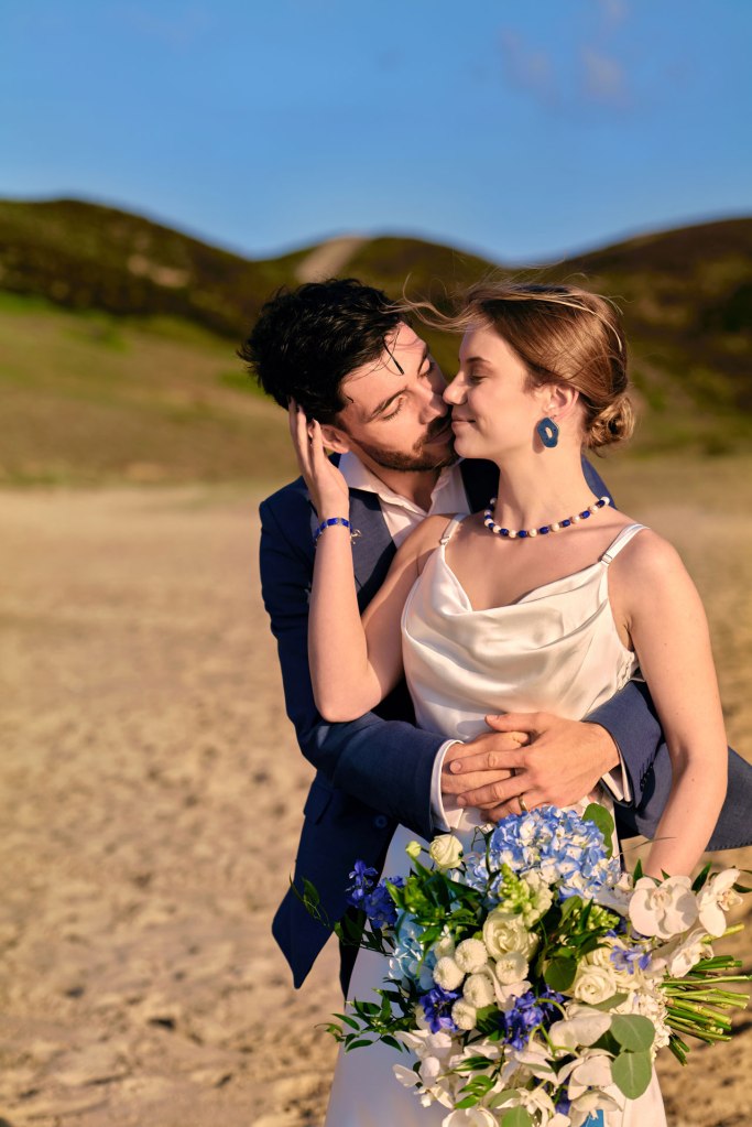 Elopement Portugal Strand – romantische Umarmung Brautpaar bei goldenem Abendlicht © Chirlyart