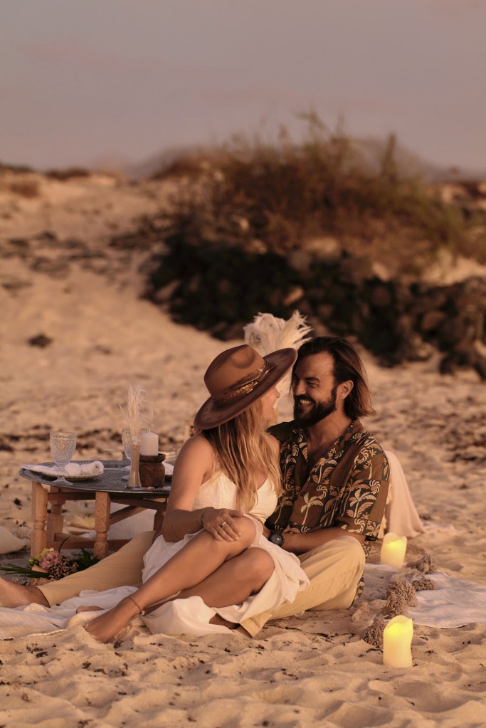 Elopement Kanaren – Dhana und Sascha Küss am Strand, Laternen Holztisch Zeremoniedeko © Chirlyart