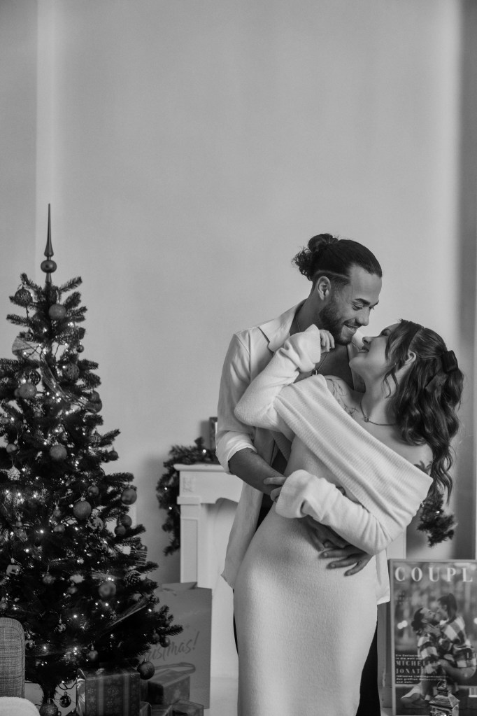 Weihnachts-Paarfotografie Köln – Paar küsst sich vor dem Weihnachtsbaum © Chirlyart