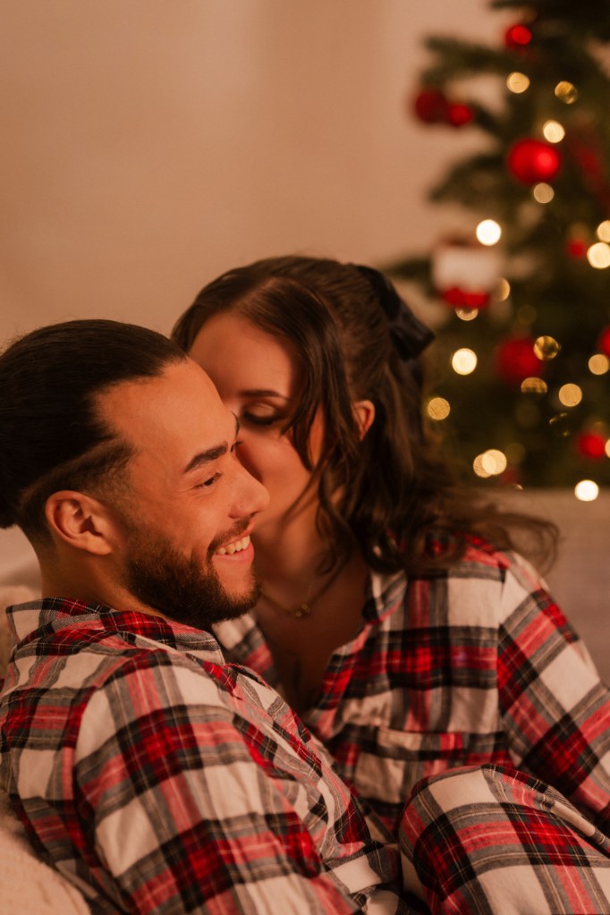 Paarfotografie Weihnachten – Paar lacht ausgelassen auf dem Sofa © Chirlyart