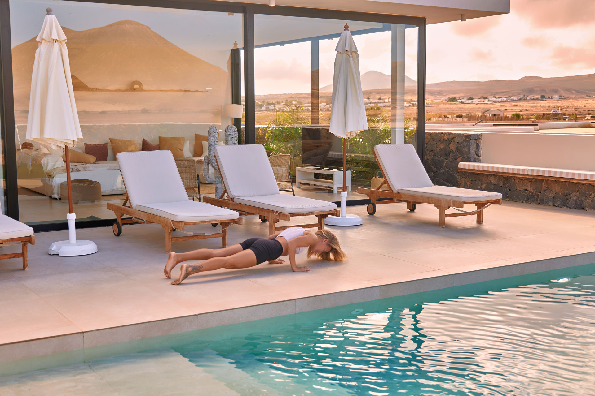 Yoga Shooting moderne Villa Fuerteventura – Frau in Krieger-Pose auf Terrasse, klare Architektur und Ausblick © Chirlyart