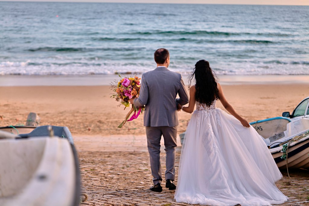 Farbenfrohes Elopement Algarve – Brautpaar vor Bougainvilleen Fassade Portugal © Chirlyart