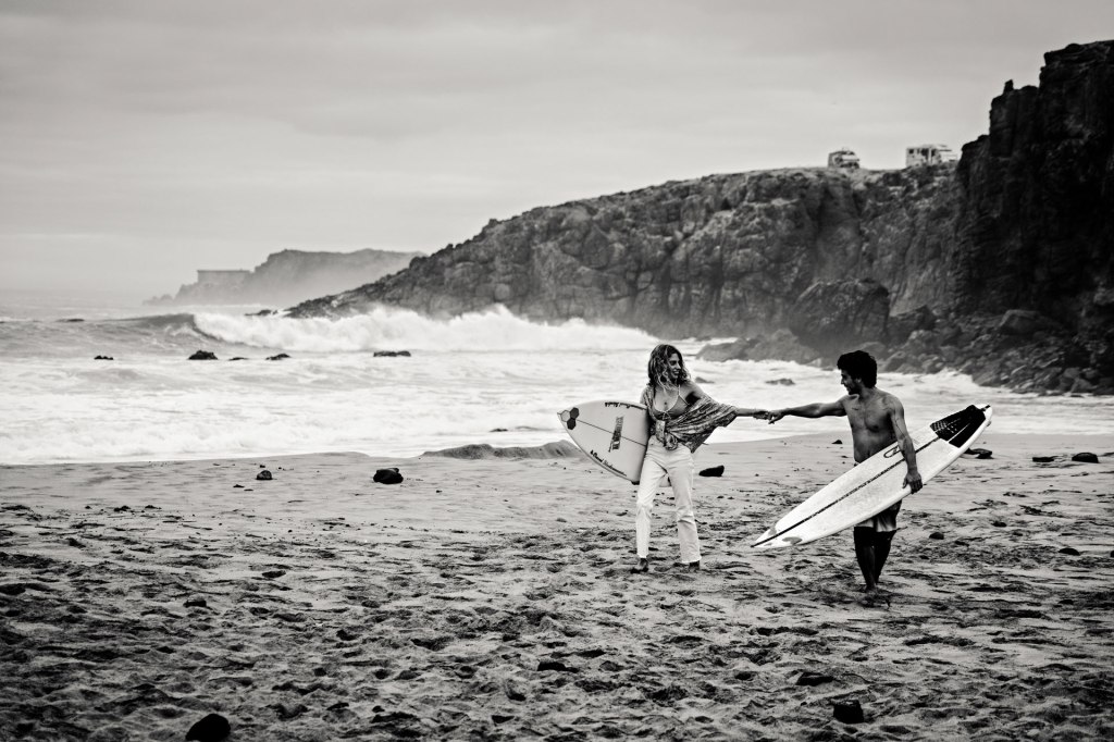 Ocean Kiss Fuerteventura – Paar am Strand mit Surfboard, goldene Stunde Kanaren Atlantik © Chirlyart