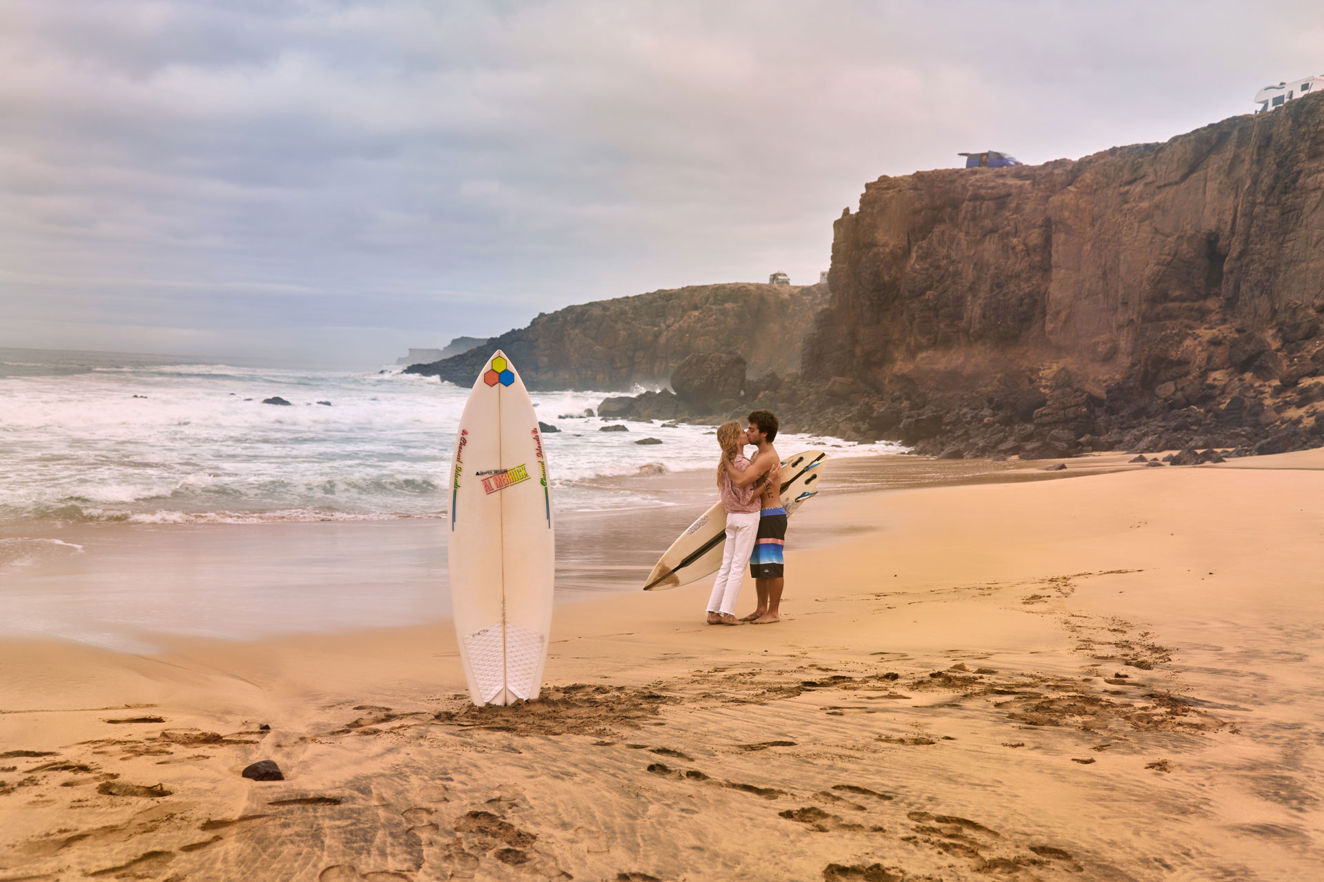 Ocean Kiss Fuerteventura Strand – Paar in romantischem Abendlicht, wilde Atlantik Wellen Kanaren © Chirlyart
