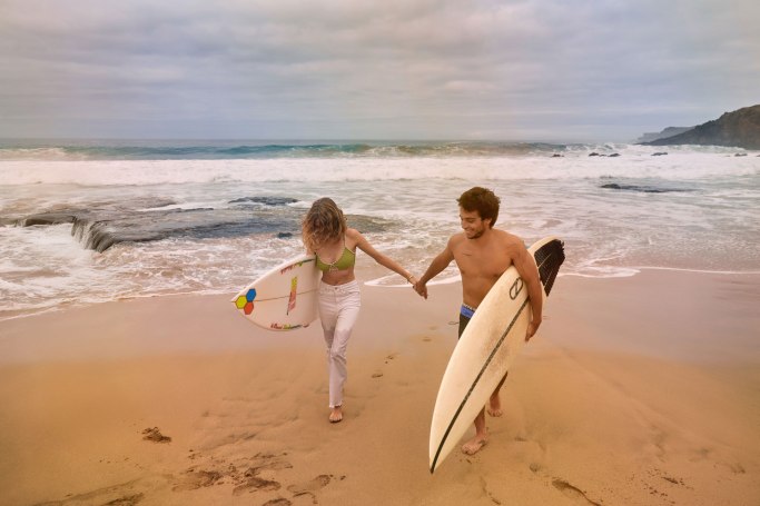 Surfer Paar Fuerteventura – Kuss am Atlantikstrand, goldenes Abendlicht Kanaren © Chirlyart