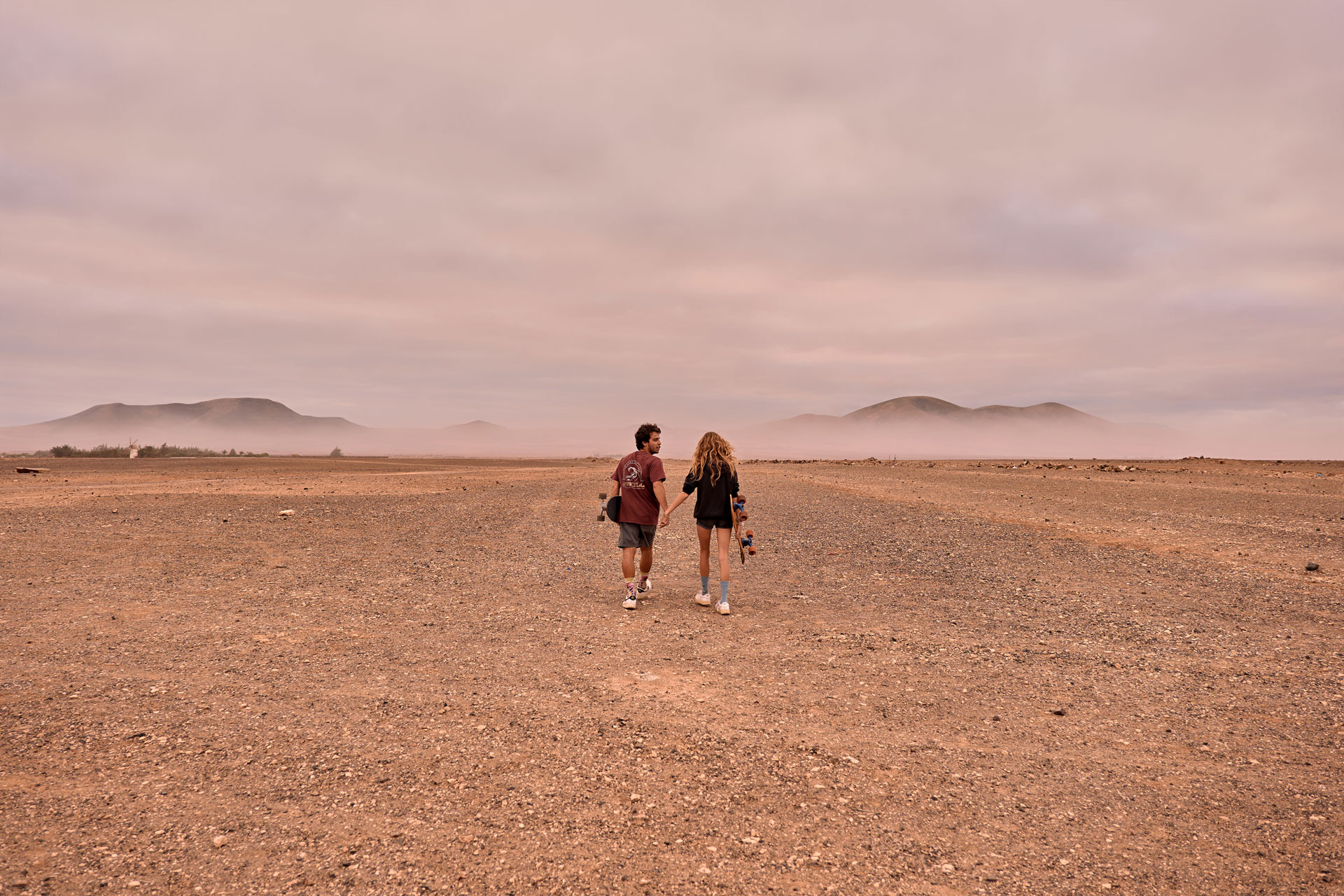 Ride and Romance Fuerteventura Weitwinkel – Paar auf Skateboards in epischer Landschaft Kanaren © Chirlyart
