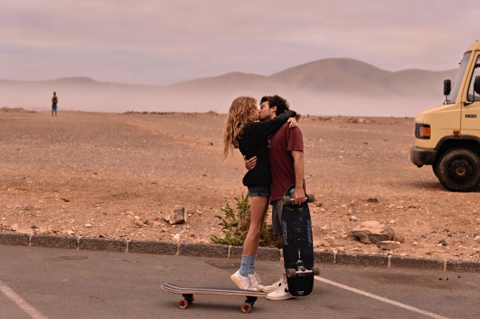Ride Romance Kanaren – Paar auf Skateboards nebeneinander, weite Straße Fuerteventura © Chirlyart