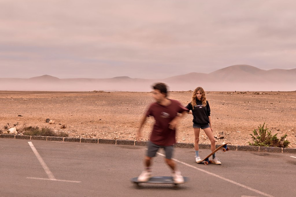 Skater Paar Fuerteventura – gemeinsame Fahrt auf dem Board, Sonne und weite Landschaft Kanaren © Chirlyart