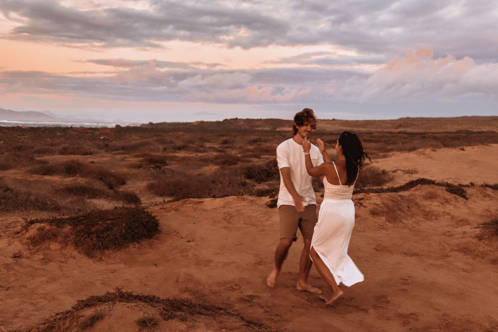 Couple Shooting Kanaren Dünen – Paar läuft Silhouette gegen goldenen Abendhimmel Fuerteventura © Chirlyart